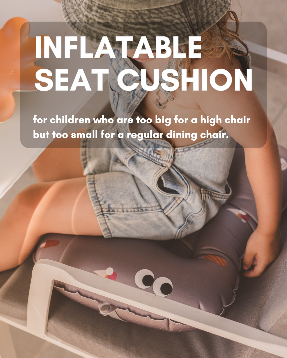 alt="Inflatable ergonomic booster cushion for children with elastic strap and anti-slip backing, placed on a dining chair"