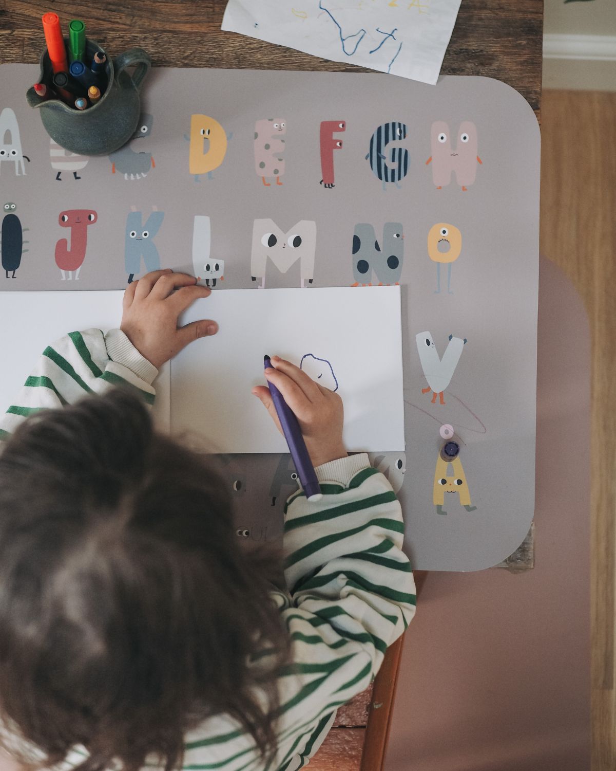 Placemat with the alphabet displayed in a playful design. Available in English, Danish and German.