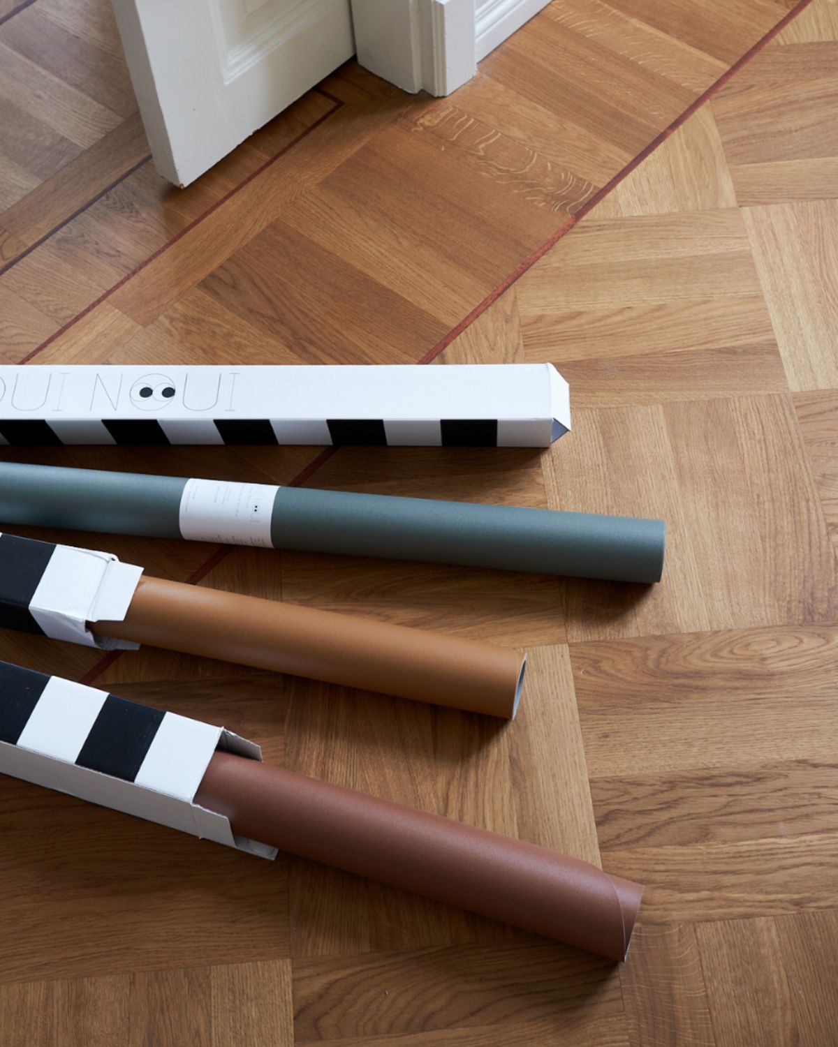 A rectangular grey powder high chair floor mat. Size 120 x 95 cm. Rolled and easy to store.