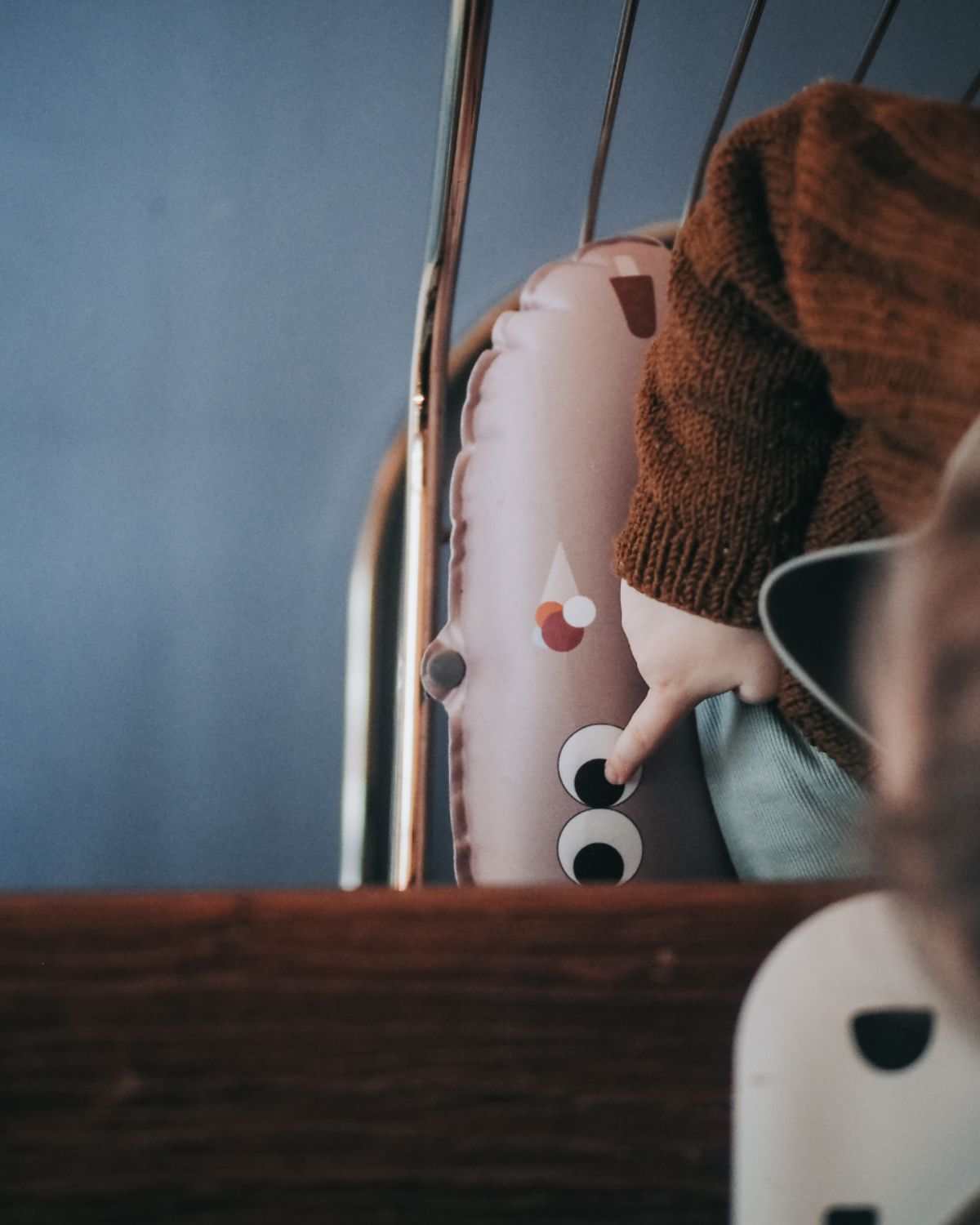 alt="Inflatable ergonomic booster cushion for children with elastic strap and anti-slip backing, placed on a dining chair"