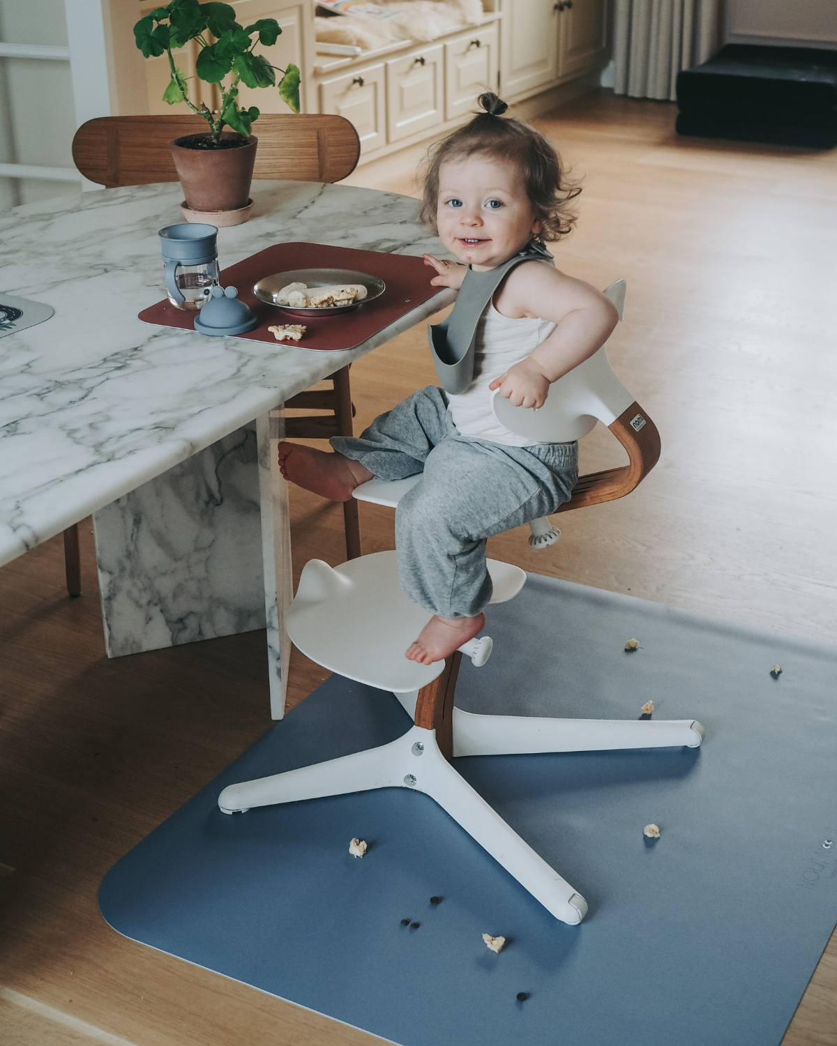 A dusty blue high chair floor mat. A rectangular high chair floor mat to protect all kind of floors from spills. Put it under the high chair.