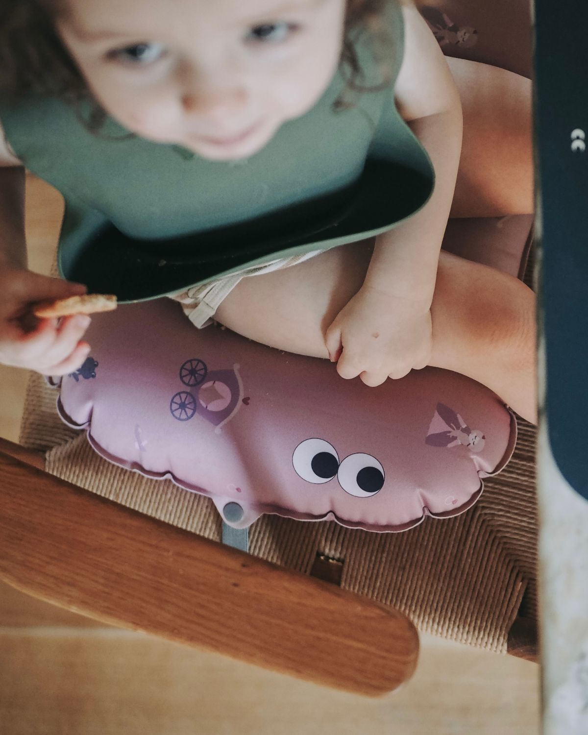 Inflatable child booster seat cushion Elastic strap to secure the cushion on the chair with a pattern of princesses and carrige.