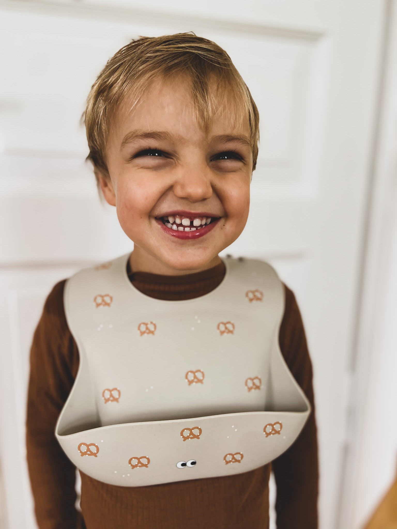 A child wearing our soft silicone bib with breze. It has an extra large cup and adjustable strap in the back.