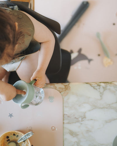 Placemat with cute wild ocean animals like whales and jellyfish in stylish color tones on a nude background. Paired with matching floor mat under the child high chair. 