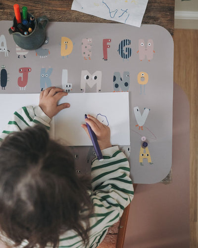 Placemat with the alphabet displayed in a playful design. Available in English, Danish and German.