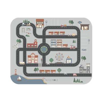 A XL placemat with different small cars and road map design, featuring buildings, trees, and a Ferris wheel.