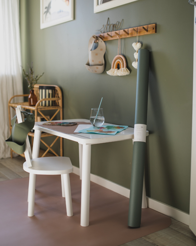 A rectangular dusty olive high chair floor mat laid out flat. Rolled and ready to be stored. 