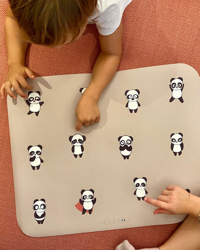Placemat with a nude background and multiple illustrations of pandas in various moods, such as happiness, sadness and many other moods.