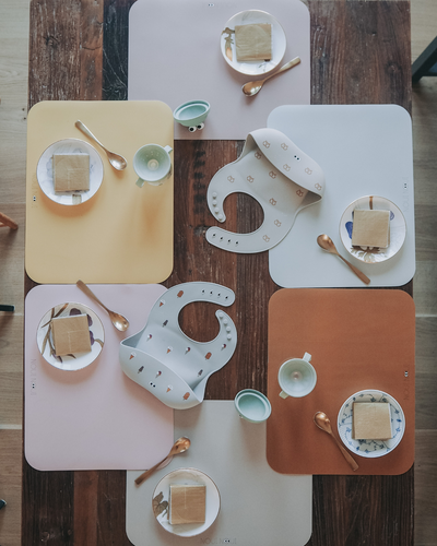 Various display of our placemat on a table setting with cups and plates.